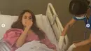 Tampak ia kenakan baju pasien warna pink dan terbaring lemah di ranjang. Sejumlah suster merawatnya. (instagram.com/claurakiehl)