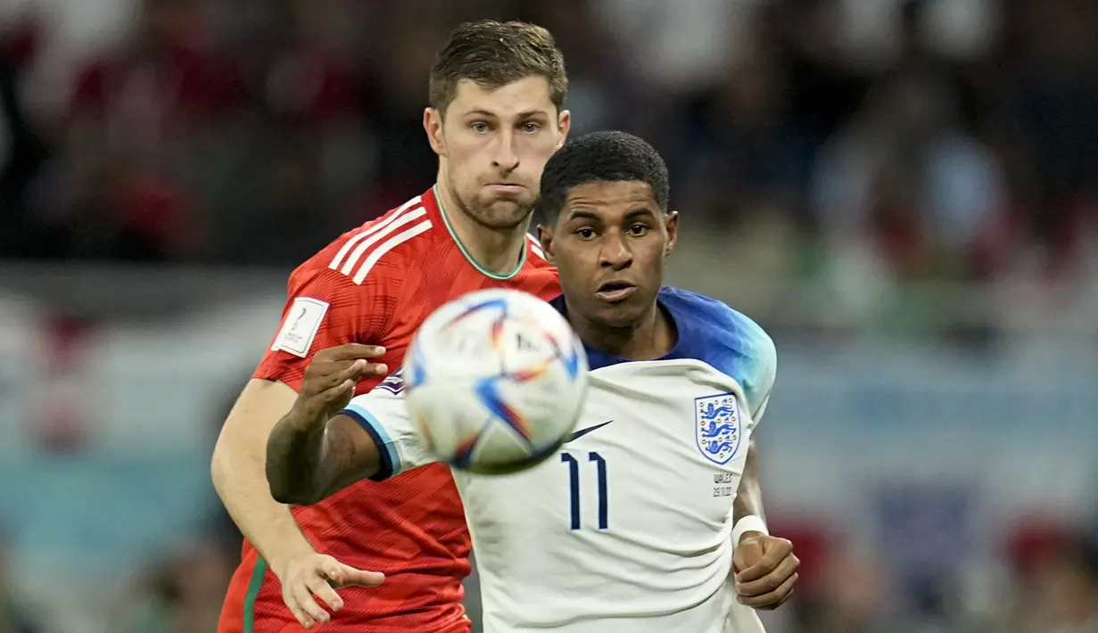 <p>Pemain Inggris, Marcus Rashford (kanan) berebut bola dengan pemain Wales, Ben Davies saat matchday ketiga Grup B Piala Dunia 2022 di Ahmad Bin Ali Stadium, Rabu (30/11/2022). (AP/Abbie Parr)</p>