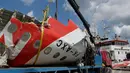 Bagian ekor pesawat AirAsia QZ8501 dinaikan keatas truk kontainer untuk dibawa menuju gudang penyimpanan di Pelabuhan Panglima Utar, Kumai, Kalimantan Tengah, Senin (12/01/2015). (Liputan6.com/Andrian M Tunay)