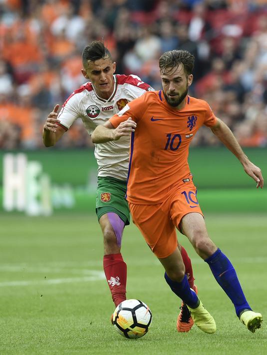 Pemain Bulgaria, Georgi Kostadinov (kiri) gagal menahan laju pemain pemain Belanda, Davy Propper pada laga grup A kualifikasi Piala Dunia 2018 di Amsterdam, (3/9/2017). Belanda menang 3-1. (AFP/John Thys)