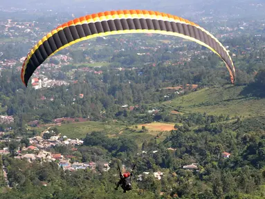 Olahraga Paralayang menjadi pilihan warga yang berkunjung ke Puncak Pass, Bogor, Jumat (6/4). Olahraga yang memacu adrenalin ini dipatok dengan harga Rp. 350 Ribu. (Liputan6.com/Johan Tallo)