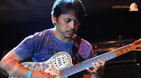 Dewa Budjana dengan gaya khasnya memainkan gitarnya saat malam amal penggalangan dana untuk korban bencana di Indonesia (Liputan6.com/Faisal R Syam).