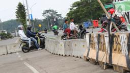 Pengendara motor menerobos beton pembatas di kawasan lingkar Stadion Pakansari, Kabupaten Bogor, Jawa Barat, Rabu (10/6/2020). Hingga Rabu (10/6), Pemkab Bogor masih menutup kawasan Stadion Pakansari untuk semua kegiatan sebagai upaya pencegahan penyebaran COVID-19. (Liputan6.com/Helmi Fithriansyah)