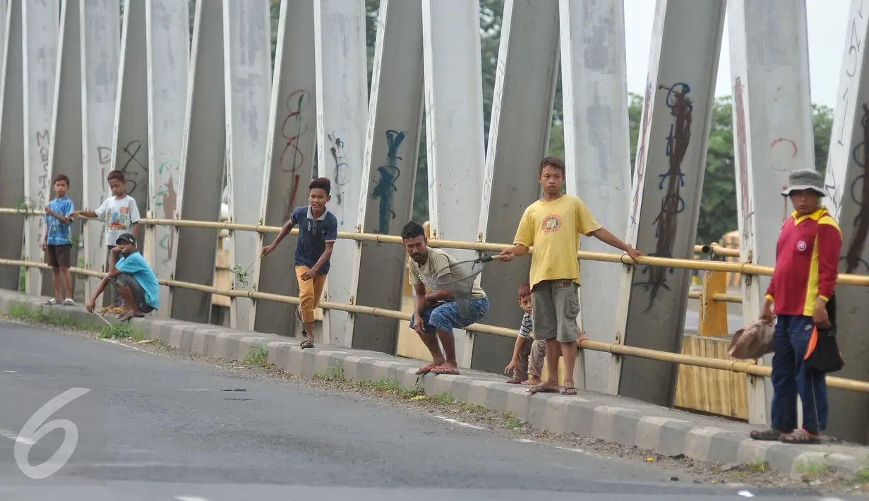 Sejumlah bocah menunggu pengendara yang melintas untuk melempar uang koin di Jembatan Cikalong, Jawa Barat, Sabtu (2/7). Memasuki mudik Lebaran, jumlah pencari uang sedekah di kawasan itu meningkat dibanding hari biasa. (Liputan6.com/Gempur M Surya)