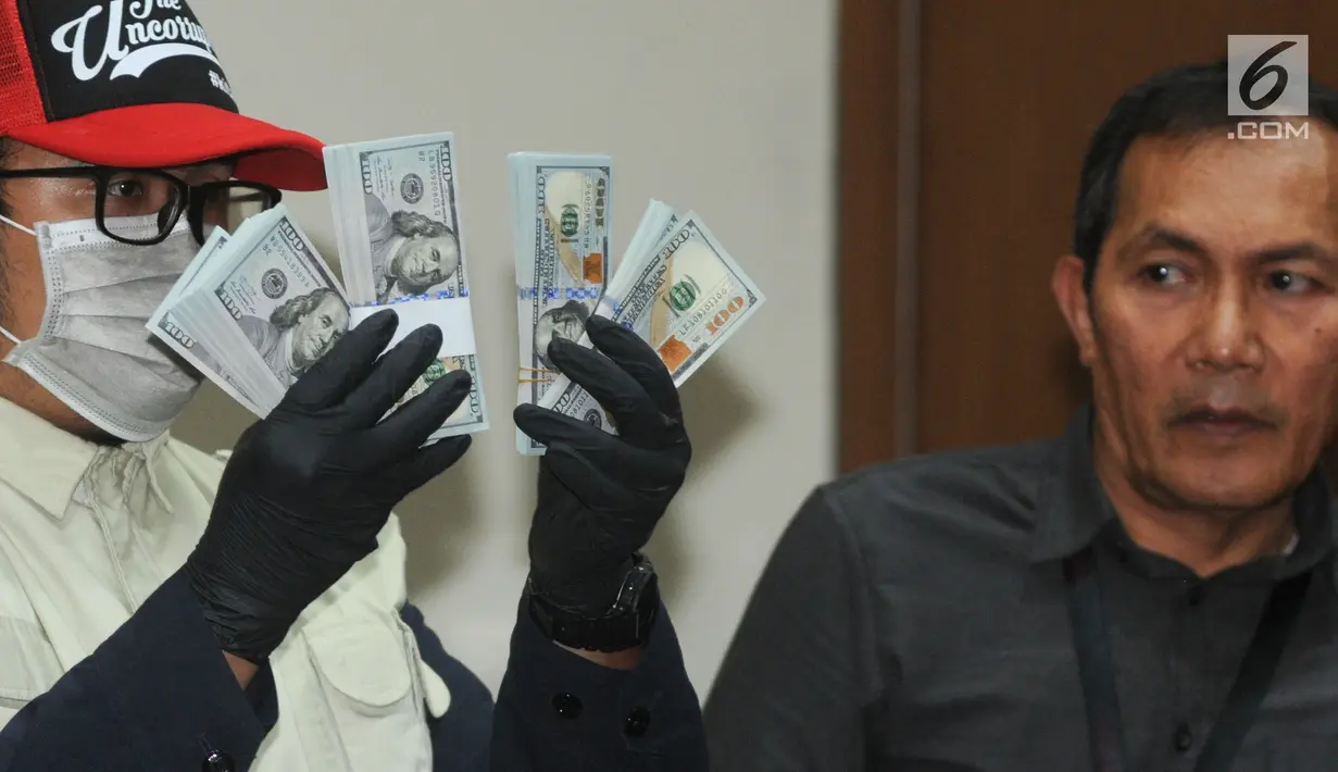 Petugas menunjukkan barang bukti uang sebesar USD 30 ribu hasil OTT kasus dugaan suap kuota impor ikan di Gedung KPK, Jakarta, Selasa (24/09/2019). KPK menetapkan dua tersangka Dirut Perum Perindo, Risyanto Suanda dan penyuap Direktur PT Navy Arsa Sejahtera Mujib Mustoda. (merdeka.com/Dwi Narwoko)