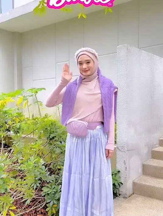 Nggak melulu pink, kali ini Inara memadukan turtleneck top warna soft pink dengan cardigan lilac dan tiered skirt warna lavender. [Instagram/inararusli].