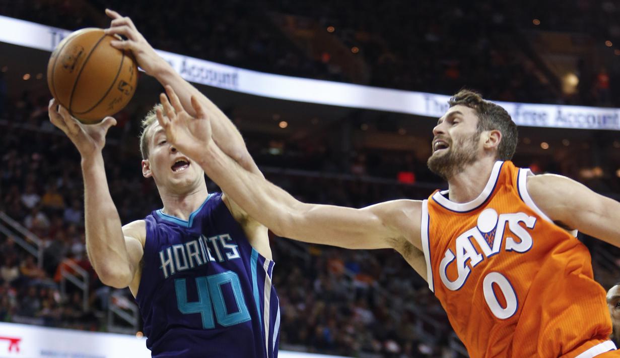 Pemain Charlotte Hornets, Cody Zeller #40 mencoba memasukan bola melewati pemain Cleveland Cavaliers, Kevin Love #0 pada laga NBA di Quicken Loans Arena, (10/12/2016). (AP/Ron Schwane)