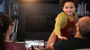 Ahmad Kamel mengangkat putranya Yusuf Kamel ketika istrinya Nadia Chaouch duduk di sebelah mereka ketika keluarga menyaksikan streaming langsung doa Taraweeh ketika mereka menunggu berbuka puasa Ramadan di rumah mereka selama wabah coronavirus di Seattle (28/4/2020). (AP/Elaine Thompson)