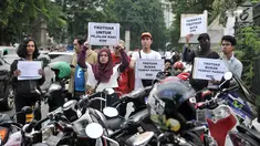 Koalisi Pejalan Kaki membawa poster saat menggelar aksi Tamasya Trotoar Kita di lokasi parkir liar sepanjang jalur pedestrian Gelora Bung Karno (GBK), Jakarta, Minggu (9/12). (Merdeka.com/Iqbal S. Nugroho)