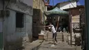 Seorang pria mengayunkan tongkat saat memainkan permainan tradisional "chapitas" atau Caps, di Caracas, Venezuela, 29 Januari 2022. Permainan populer mirip dengan bisbol ini dimainkan dengan tutup botol sebagai pengganti bola, dan tongkat sebagai pengganti pemukul. (AP/Matias Delacroix)