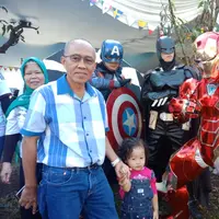 Warga tampak antusias berfoto bersama 2 super hero, yaitu Iron Man, Batman dan Captain America di TPS 21, Kelurahan Cigadung, Kecamatan Cibeunying Kaler, Kota Bandung. (Liputan6.com/Huyogo Simbolon)