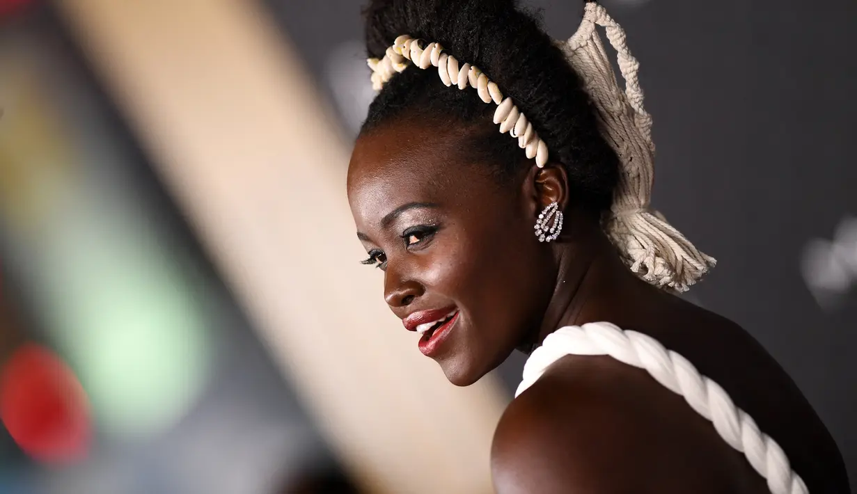 Lupita Nyong'o berpose saat menghadiri pemutaran perdana film Black Panther: Wakanda Forever" di Dolby Theatre di Los Angeles pada Rabu, 26 Oktober 2022.  Bibirnya dicat dengan warna merah mengkilap dan dia memakai shimmer di matanya untuk tampilan yang bercahaya.  (AFP/Valerie Macon)