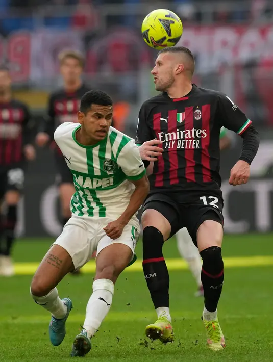 Pemain Sassuolo Rogerio (kiri) bersaing memperebutkan bola dengan pemain AC Milan Ante Rebic pada pertandingan sepak bola Liga Italia di Stadion San Siro, Milan, Italia, 29 Januari 2023. AC Milan dipermalukan 2-5 oleh Sassuolo. (AP Photo/Antonio Calanni)