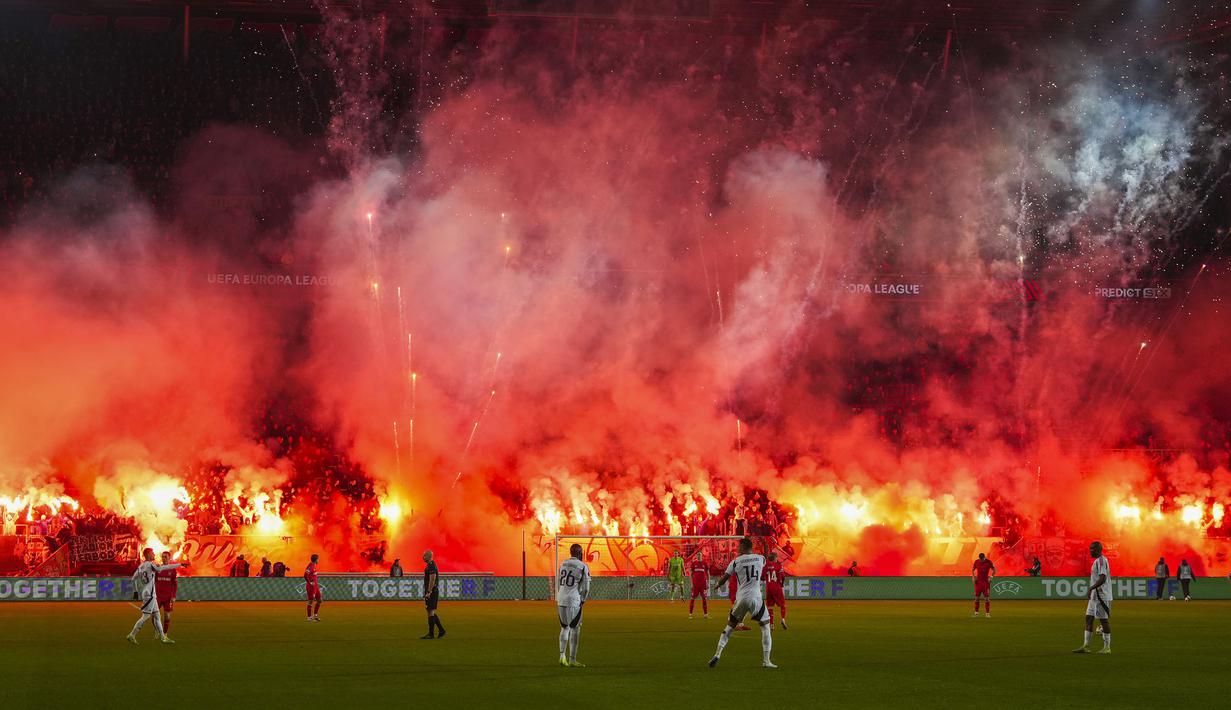 Pendukung FC Twente menyalakan suar dan kembang api menjelang dimulainya babak kedua pertandingan Liga Europa 2024/2025 melawan Besiktas di De Grolsch Veste stadium, Enschede, Belanda, Jumat (31/01/2025) dini hari WIB. (AP Photo/Peter Dejong)