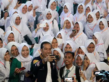 Presiden Joko Widodo atau Jokowi berswafoto dengan siswa SMA penerima Kartu Indonesia Pintar (KIP) di Gorontalo, Jumat (1/3). Tahun 2019 Provinsi Gorontalo mendapatkan jatah 80.502 KIP. (Liputan6.com/Arfandi Ibrahim)