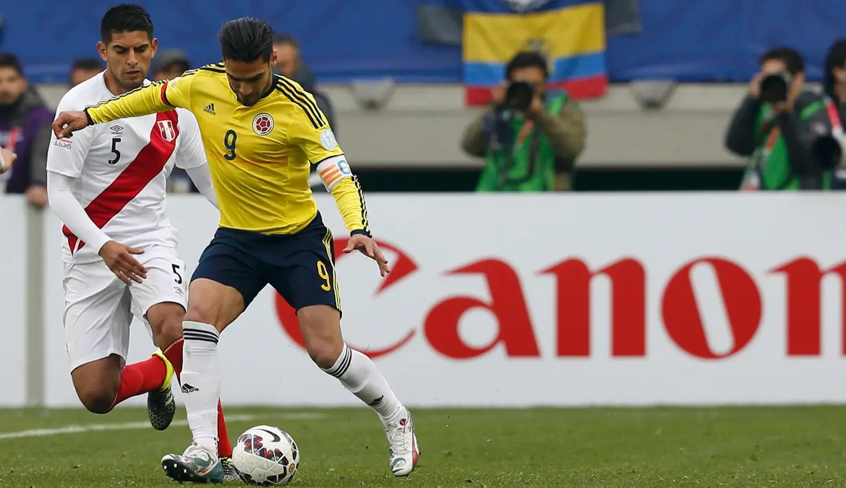 Penyerang Kolombia, Radamel Falcao (kanan) berusaha melewati bek Peru, Carlos Zambran di pertandingan Copa Amerika 2015 di Stadion Municipal Bicentenario, Chili, (22/6/ 2015). Peru lolos ke perempat final Copa America 2015. (REUTERS/Carlos Garcia Rawlins)