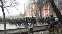 Polisi anti huru hara berjalan untuk memblokir demonstran yang berkumpul selama protes di Almaty, Kazakhstan, Rabu (5/2/2022). Demonstran yang menolak kenaikan harga gas cair bentrok dengan polisi di kota terbesar Kazakhstan dan mengadakan protes di sekitar kota. (AP Photo/Vladimir Tretyakov)