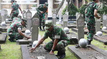 Personel TNI mencabut rumput liar saat membersihkan Taman Makam Pahlawan Kalibata di Jakarta, Kamis (9/11). Pembersihan tersebut dilakukan guna menyambut Hari Pahlawan yang diperingati setiap 10 November. (Liputan6.com/Immanuel Antonius)