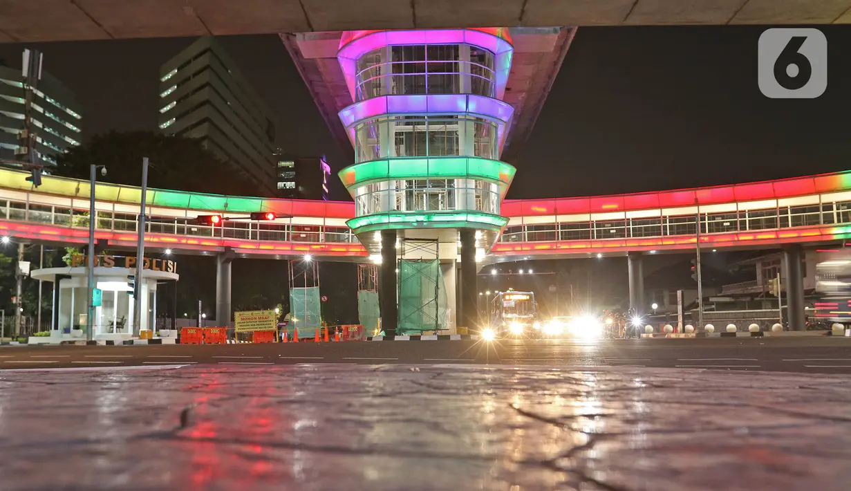 Cahaya warna-warni menghiasi Halte Transjakarta Centrale Stichting Wederopbouw (CSW) di kawasan Kebayoran Baru, Jakarta, Kamis (29/07/2021). Skybridge yang mengintegrasikan Halte Transjakarta CSW dengan Stasiun MRT Asean mengambil desain Cakra Selaras Wahana. (Liputan6.com/Herman Zakharia)