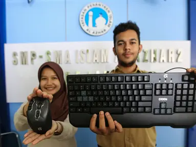 Dua siswa menunjukkan mouse dan keyboard Logitech di SMA Al-Azhar 2 Pejaten, Jakarta, Rabu (14/8/2019). Logitech berkomitmen untuk mendukung kemajuan eSport di Indonesia dengan memberikan peralatan gaming Logitech G dengan harapan mampu melahirkan atlet eSport yang berbakat. (Liputan6.com/HO/Ady)