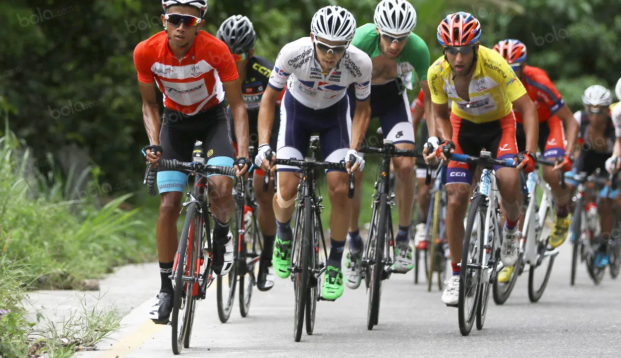 Pebalap Terengganu Cycling Team asal Indonesia, Dady Suryadi (kiri), bersaing ketat dengan para pebalap Iran pada Etape 6 dari Padang Pariaman menuju Sawahlunto, Sumatera Barat, Kamis (11/8/2016).  (Bola.com/Nicklas Hanoatubun)