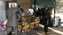 Peti mati berisi jenazah George Floyd dibawa setelah penghormatan terakhir di Gereja Fountain of Praise, Houston, Amerika Serikat, Senin (8/6/2020). Jenazah George Floyd disemayamkan dalam sebuah peti mati berlapis emas. (Godofredo A. Vásquez/Houston Chronicle via AP, Pool)