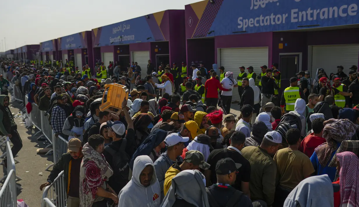 Penggemar mengantre di luar Stadion Al Janoub di Wakrah, dengan harapan mendapatkan tiket pertandingan sepak bola semifinal Piala Dunia 2022 antara Prancis vs Maroko, Selasa (13/12/2022). Partai hidup mati akan tersaji antara timnas Prancis melawan Maroko pada babak semifinal Piala Dunia 2022 di Stadion Al Bayt, Kamis (15/12) dini hari WIB. (AP Photo/Francisco Seco)
