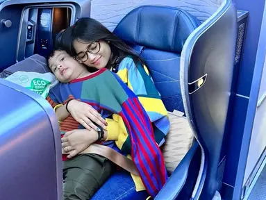 Momen liburan Gala dan Fuji ke luar negeri ini sembari merayakan ulang tahun mendiang ayah Gala, Bibi Adriansyah. Saat di bandara hingga di dalam pesawat, Fuji aktif bagikan kegiatan Gala yang antusias untuk liburan. Bak ibu untuk Gala, mantan Thariq Halilintar ini sangat sabar dan telaten mengurus Gala agar selalu merasa nyaman selama dalam perjalanan. (Liputan6.com/IG/@fuji_an)