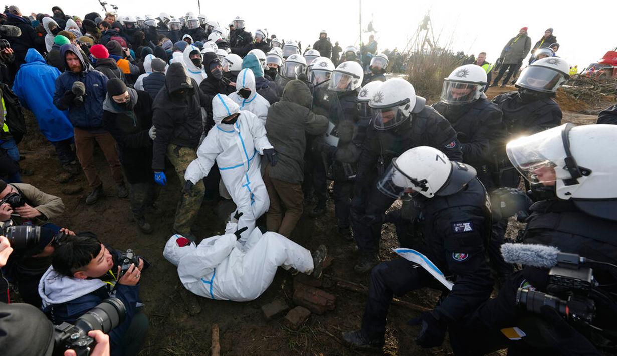 Polisi dan demonstran bertemu di sebuah jalan di Desa Luetzerath dekat Erkelenz, Jerman, 10 Januari 2023. Desa Luetzerath diduduki oleh aktivis iklim yang berjuang melawan penghancuran desa untuk memperluas tambang batu bara Garzweiler dekat perbatasan Belanda. (AP Photo/Michael Probst)
