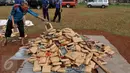 Petugas menyiapkan kemasan ganja untuk dimusnahkan di Mapolsek Palmerah, Jakbar, Senin (15/6). Barang bukti yang dimusnahkan berupa 10.286 botol miras, 561 kg ganja, 1,4 kg sabu, 7.668 butir ekstasi, 1.000 butir psikotropika. (Liputan6.com/Johan Tallo)