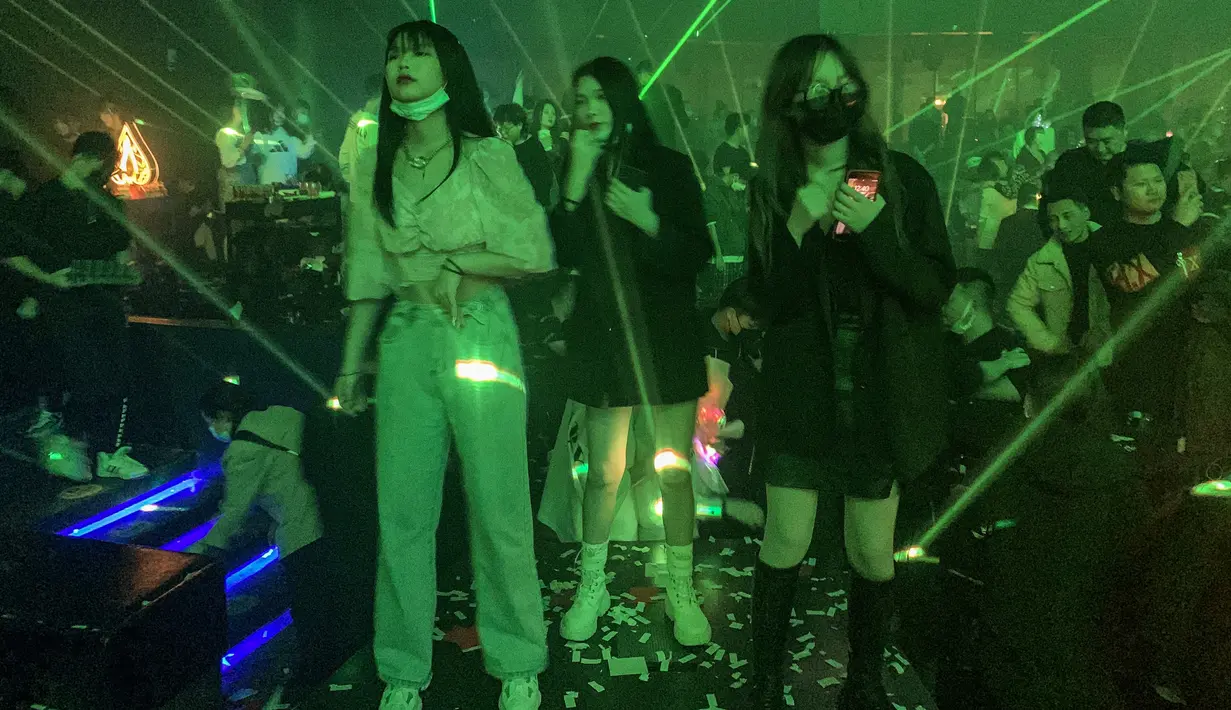 Sejumlah wanita saat berada di dalam kelab malam di Wuhan, provinsi Hubei, China (21/1/2021). Sebuah kelab malam besar di Wuhan kembali menggeliat usai lockdown di tahun 2020. (AFP/Hector Retamal)