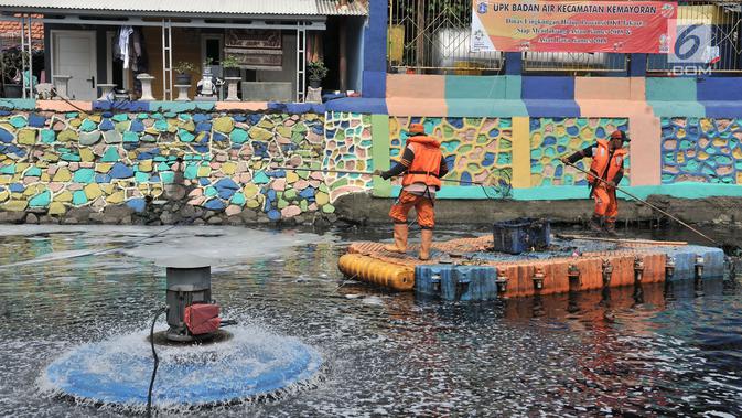 Petugas PPSU membersihkan sampah saat pengoperasian Nano Bubble dan Aerator di Kali Item, Jakarta, Kamis (2/8). Berbagai cara, dari pemberian oksigen melalui pengoperasian Nano Bubble dan Aerator hingga penyedotan 24 jam. (Merdeka.com/Iqbal S. Nugroho)