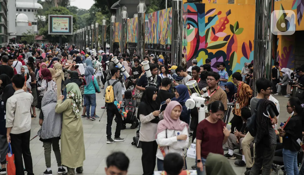 Suasana saat para pengunjung mengamati gerhana matahari cincin di Planetarium Taman Ismail Marzuki, Jakarta, Kamis (26/12/2019). Planetarium menyediakan sekitar 10 teleskop dan kacamata khusus agar pengunjung bisa menyaksikan gerhana matahari cincin dengan aman. (Liputan6.com/Faizal Fanani)