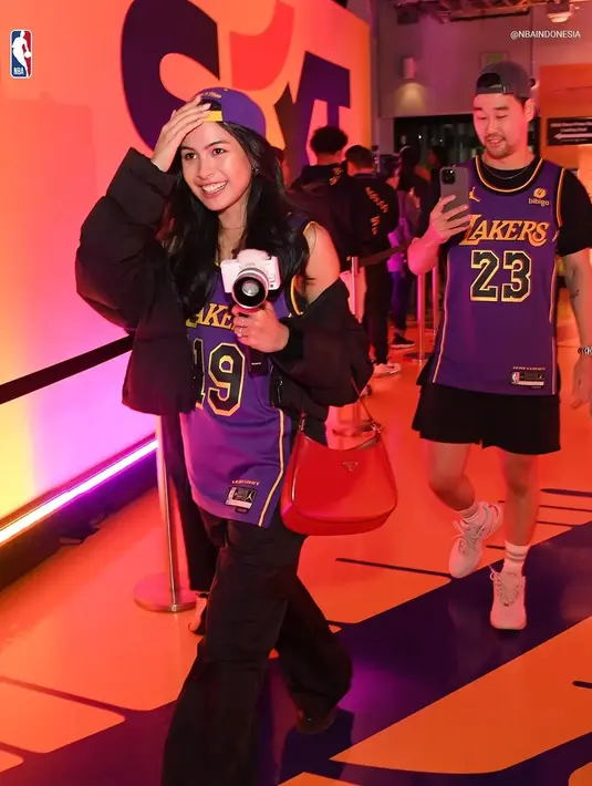 Tampilan Maudy kenakan jersey ini terlihat modis dengan puffy jackets dan shoulder bag merah [@nbaindonesia]