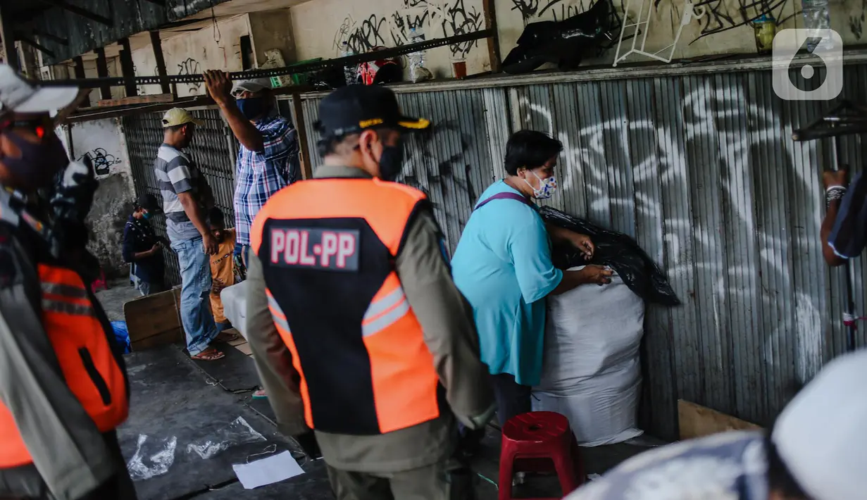 Petugas Satpol PP menertibkan pedagang yang nekat berjualan saat masa pandemi COVID-19 di kawasan Pasar Tanah Abang, Jakarta, Jumat (22/5/2020). Gubernur DKI Jakarta Anies Baswedan menambah PSBB selama 14 hari mulai tanggal 22 Mei 2020. (Liputan6.com/Faizal Fanani)