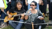Dewa Budjana memainkan gitar mengiringi nyanyian pujian di pemakaman Ireng Maulana. [Foto: Herman Zakharia/Liputan6.com]