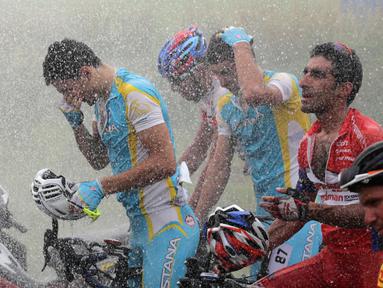Para pebalap menikmati guyuran air dari petugas pemadam kebakaran sesaat setelah finis Etape 3 Tour de Singkarak 2015 di Dharmasraya, Sumatra Barat, Senin (5/10/2015). (Bola.com/Arief Bagus)