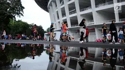Warga berjalan santai melintasi kawasan lingkar luar Stadion Gelora Bung Karno (GBK), Jakarta, Minggu (21/1). Pascarenovasi, kawasan sekitar Stadion GBK kembali dipadati warga yang berolahraga. (Liputan6.com/Helmi Fithransyah)