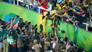 Usain Bolt melakukan selebrasi bersama penggemarnya usai meraih emas kategori sprint 100 meter Olimpiade 2016 di Rio de Janeiro, Brasil, (15/8). Bolt finish dengan catatan waktu 9,81 detik. (REUTERS/Carlos Barria)     