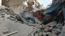 Sebuah alat berat dikerahkan untuk mencari korban yang tertimbun reruntuhan akibat serangan udara di distrik al-Fardous, , Aleppo, Suriah, Rabu (12/10). Akibat serangan udara tersebut telah menewaskan sedikitnya 15 orang. (REUTERS/Abdalrhman Ismail)