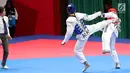 Atlet taekwondo putri Makau, Liu Qing melayangkan tendangannya ke arah Fitriyana Yusuf dari Indonesia pada babak 16 besar di Jakarta Convention Center (JCC), Senin (20/8). Fitriyana kalah tipis 21 - 25 pada kelas Wanita 67 kg. (Liputan6.com/Fery Pradolo)