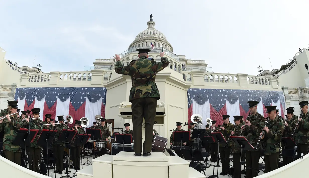 Dirigen memandu anggota President's Own Marine Band memainkan musik saat gladi resik jelang pelantikan Donald Trump di U.S. Capitol, Washington, DC, AS (19/1). Sekitar 900.000 orang akan berkumpul ditempat tersebut. (AFP Photo/Timothy A. Clary)