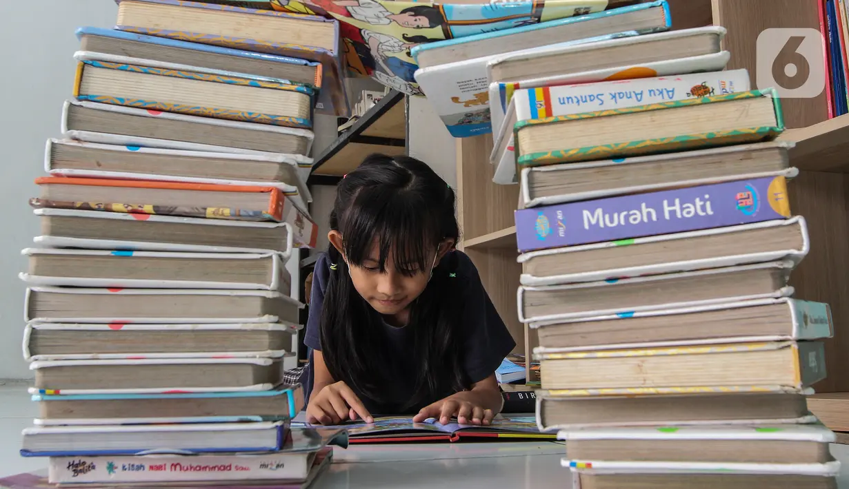 Anak-anak membaca buku saat PPKM Level 3 di Taman Baca Masyarakat Pekan Karya, Tangerang Selatan, Banten, Selasa (8/2/2022). Pemerintah daerah di wilayah aglomerasi Jabodetabek akhirnya bisa menghentikan proses PTM setelah ditetapkan sebagai daerah berstatus PPKM level 3. (Liputan6.com/Johan Tallo)