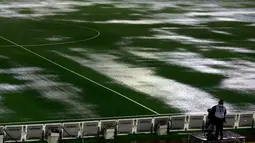 Seorang kamerawan saat berada dipinggir lapangan tergenang air akibat hujan lebat di stadion Monumental, Argentina, Jumat (13/11/2015). Karena cuaca buruk Pertandingan antara Argentina dan Brasil mengalami pengunduran. (REUTERS/Marcos Brindicci)