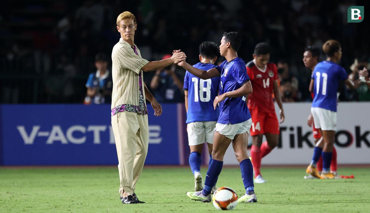 Pelatih Timnas Kamboja U-22, Keisuke Honda berjabat tangan dengan pemainnya setelah laga Grup A Sepak Bola SEA Games 2023 melawan Timnas Indonesia di Olympic National Stadium, Phnom Penh, Kamboja, Rabu (10/5/2023) malam WIB. Honda terkenal dengan gaya berpakaian unik saat mendampingi Kamboja pada perhelatan akbar olahraga di Asia Tenggara tersebut. (Bola.com/Abdul Aziz)