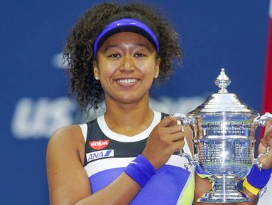 Petenis Jepang, Naomi Osaka, mengangkat trofi usai menjuarai AS Terbuka di Arthur Ashe Stadium, New York, Minggu (13/9/2020). Naomi Osaka mengalahkan Victoria Azarenka 1-6, 6-3, dan 6-3. (AP Photo/Seth Wenig)