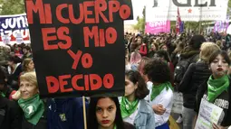 Seorang demonstran menunjukan poster saat menggelar aksi di Buenos Aires, Argentina (29/9). Dalam aksi ini mereka meminta dekriminalisasi aborsi, atau meminta perbuatan aborsi bukan lagi menjadi pelanggaran hukum. (AFP Photo/Juan Mabromata)