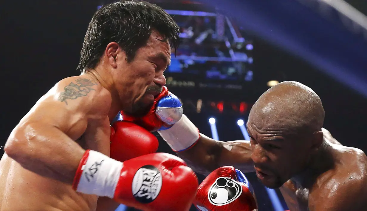 Floyd Mayweather Jr. berhasil memukul Manny Pacquiao saat pertandingan kelas welterweight di MGM Grand Garden Arena, Las Vegas, Nevada, Minggu (3/5/2015). Floyd Mayweather berhasil manang angka atas Manny Pacquiao. (REUTERS/Steve Marcus)