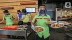 Pramusaji lengkap dengan Alat Pelindung Diri (APD) berupa face shield, sarung tangan dan masker membawa makanan untuk konsumen di Restoran Bandar Djakarta, Alam Sutera, Tangerang Selatan, Rabu (10/6/2020). Menuju new normal restoran tetap menerapkan protokol kesehatan. (Liputan6.com/Fery Pradolo)