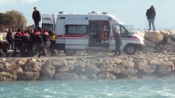 Petugas memasukkan korban tenggelam para imigran di distrik Altinoluk, Balikesir, Turki, (8/2). Diduga tenggelamnya perahu mereka karena sebuah kecelakaan. (STR / AFP)